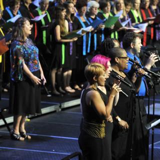 Musicians and choir perform, dressed colorfully for UU worship.