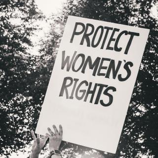 Black-and-white image of protest sign reading "Protect Women's Rights"