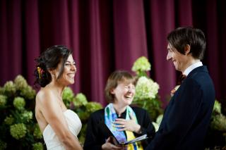 A Unitarian Universalist minister shares a laugh with a couple during their wedding ceremony.