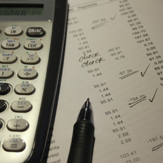 Calculator on top of financial reconciliation sheet with pen